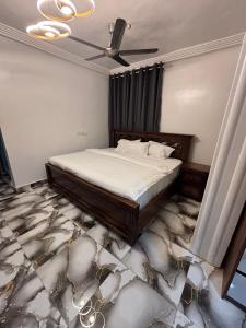 a bedroom with a bed and a ceiling fan at KELNESSA Hotel in Obuassi