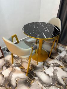a table and two chairs and a table and a table at KELNESSA Hotel in Obuassi