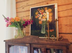 a painting of flowers and a candle on a table at Kolin Mattila B&B in Kolinkylä