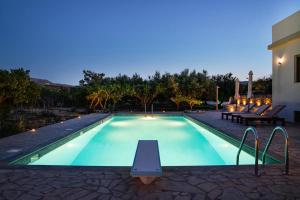 a swimming pool with a table next to a house at Panorama Villa Sitia in Sitia