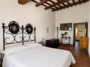 a bedroom with a white bed in a room at Castello di Mongiovino Vecchio "La Casa in Piazza" in Panicale