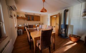 a kitchen with a table and chairs and a fireplace at Udobna hiša med vinogradi blizu Vinarium LEND - Comfortable Vineyard House near Vinarium Tower LEND in Lendava