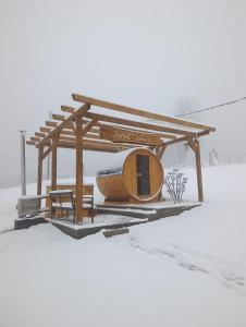 a bus stop in the snow with a wooden structure at Vikendica i odmaraliste JuliE, Sarajevo-Jahorina in Tvrdimići