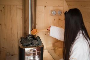 a woman is cooking food in a small stove at Vikendica i odmaraliste JuliE, Sarajevo-Jahorina in Tvrdimići