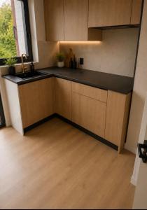 a kitchen with wooden cabinets and a sink at 250m from Tommorowland in Boom