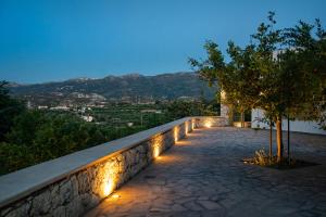 a walkway with lights on a wall at night at Panorama Villa Sitia in Sitia
