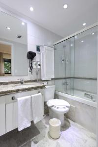 a bathroom with a toilet and a glass shower at Transamerica Paradise Garden in São Paulo +42 photos