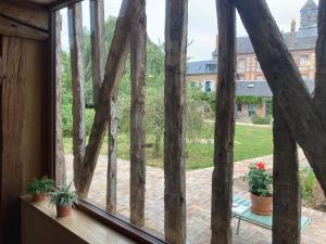 a window with a view of a yard at La Granch' - Maison d'hôtes in Harcourt