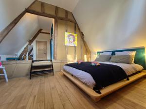 a bedroom with a large bed in a room with an attic at La Granch' - Maison d'hôtes in Harcourt