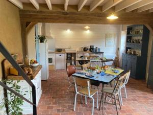 a kitchen and dining room with a table and chairs at La Granch' - Maison d'hôtes in Harcourt +13 photos