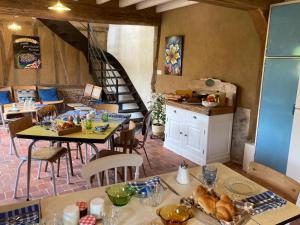a restaurant with tables and chairs and a staircase at La Granch' - Maison d'hôtes in Harcourt