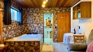 a bathroom with a tub and a sink at Pousada Florada do Amanhã in Monte Verde