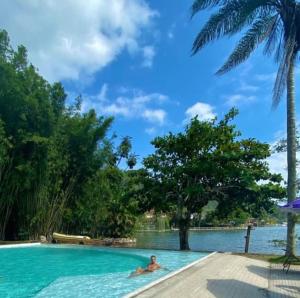 a person swimming in a large swimming pool at Ibiza Experience Resort in Angra dos Reis