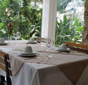 a table with wine glasses and plates on it at Ibiza Experience Resort in Angra dos Reis