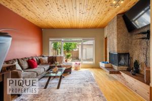 a living room with a couch and a fireplace at Urban Oasis - with 16ft Swim Spa - Heated Hot Tub & Pool in Edmonton