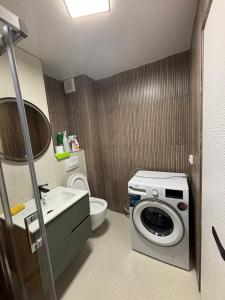 a bathroom with a washing machine and a toilet at D&D Studio in Petrila