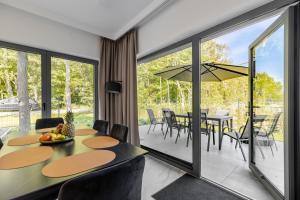 a dining room with a table and chairs and sliding glass doors at Marina Dziwnów Premium Haus 2 in Dziwnów