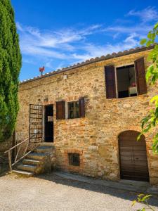 a brick building with a door and a staircase at Castello di Mongiovino Vecchio "La Casa in Piazza" in Panicale