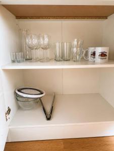 a shelf with glasses and mugs on it at Podhalańskie Chaty in Rokiciny Podhalanskie
