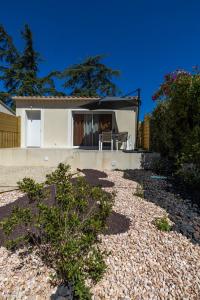 a white house with a table and chairs in a yard at Terracotta house in Sorgues