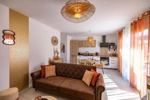 a living room with a couch and a kitchen at Terracotta house in Sorgues