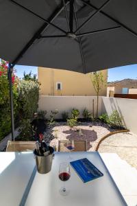 a table with a glass of wine and an umbrella at Terracotta house in Sorgues +20 photos