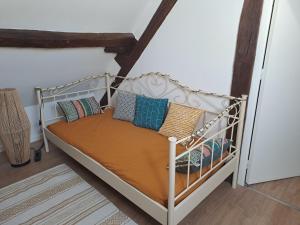 a white bed with pillows on it in a room at La Chaumière de Chabine in Oizon