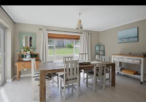 a dining room with a wooden table and chairs at Skulpie in Cape Town