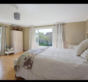 a bedroom with a large bed and a large window at Skulpie in Cape Town +5 photos