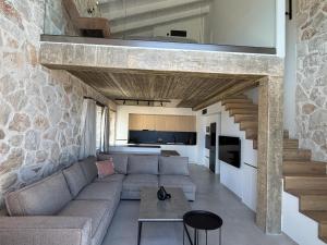 a living room with a couch and a stone wall at Izel Villas in Skinária
