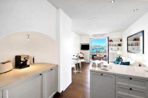 a kitchen and living room with white walls and a counter at Brentano Elegante in Mezzegra