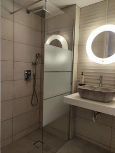 ein Badezimmer mit Waschbecken und Spiegel in der Unterkunft Blue Era Apartments in Batsi