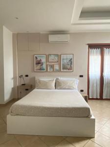 a bedroom with a large white bed in a room at Carla's studio in Pompei