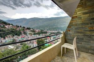 a balcony with a chair and a view of a city at Hotel O Shishamaati in Kulu