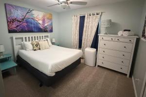a bedroom with a bed and a dresser and a painting at Glen Eagles King Nook in Colorado Springs
