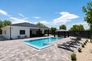 a swimming pool with a gazebo and a house at Villa Vanja in Imotski