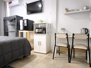a bedroom with a bed and two chairs and a table at Departamento Letty Petit - Con Cochera in San Salvador de Jujuy
