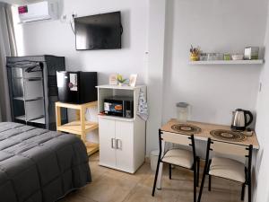 a bedroom with a bed and a table with a microwave at Departamento Letty Petit - Con Cochera in San Salvador de Jujuy