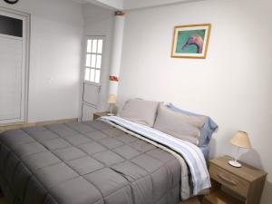 a bedroom with a bed and a picture on the wall at Departamento Letty Petit - Con Cochera in San Salvador de Jujuy