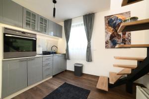 a kitchen with stainless steel cabinets and a television at Koala Resort in Raška