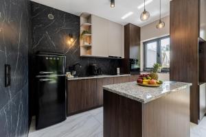a kitchen with a black refrigerator and a bowl of fruit on a counter at Marina Dziwnow Premium Haus in Dziwnów