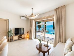 a living room with a couch and a tv at Villa Magganas in Nikiana