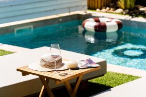 a table with a glass of wine next to a swimming pool at Villa Maya Rooftop beach access heated pool in Le Grau-dʼAgde +68 photos