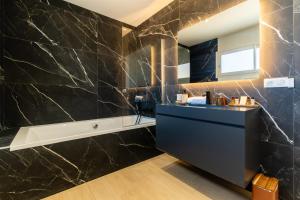 a bathroom with a black marble wall at Villa Maya Rooftop beach access heated pool in Le Grau-dʼAgde