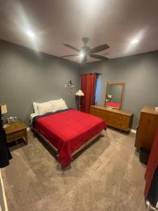 a bedroom with a red bed and a ceiling fan at Dartt's Park Flat in Owatonna