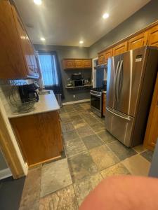 a kitchen with a stainless steel refrigerator and wooden cabinets at Dartt's Park Flat in Owatonna