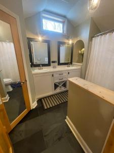 a bathroom with two sinks and two mirrors at Dartt's Park Flat in Owatonna +13 photos