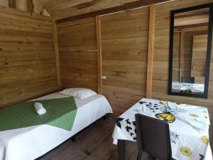 two beds in a room with wooden walls at Cabaña Vikana in Nuquí