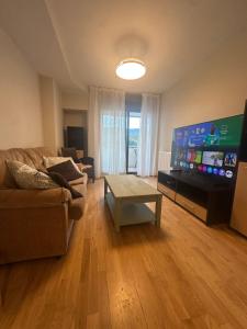 a living room with a couch and a flat screen tv at Refugio PIRENAICO in Sabiñánigo