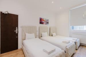 two beds sitting next to each other in a room at The Hyde Hotel in London
